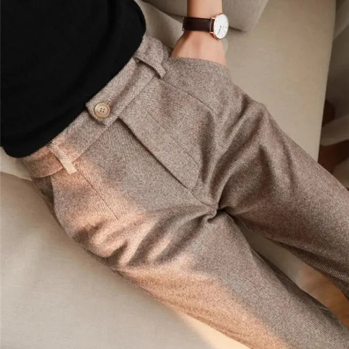 Close-up of a person wearing brown tweed pants with a blurred background