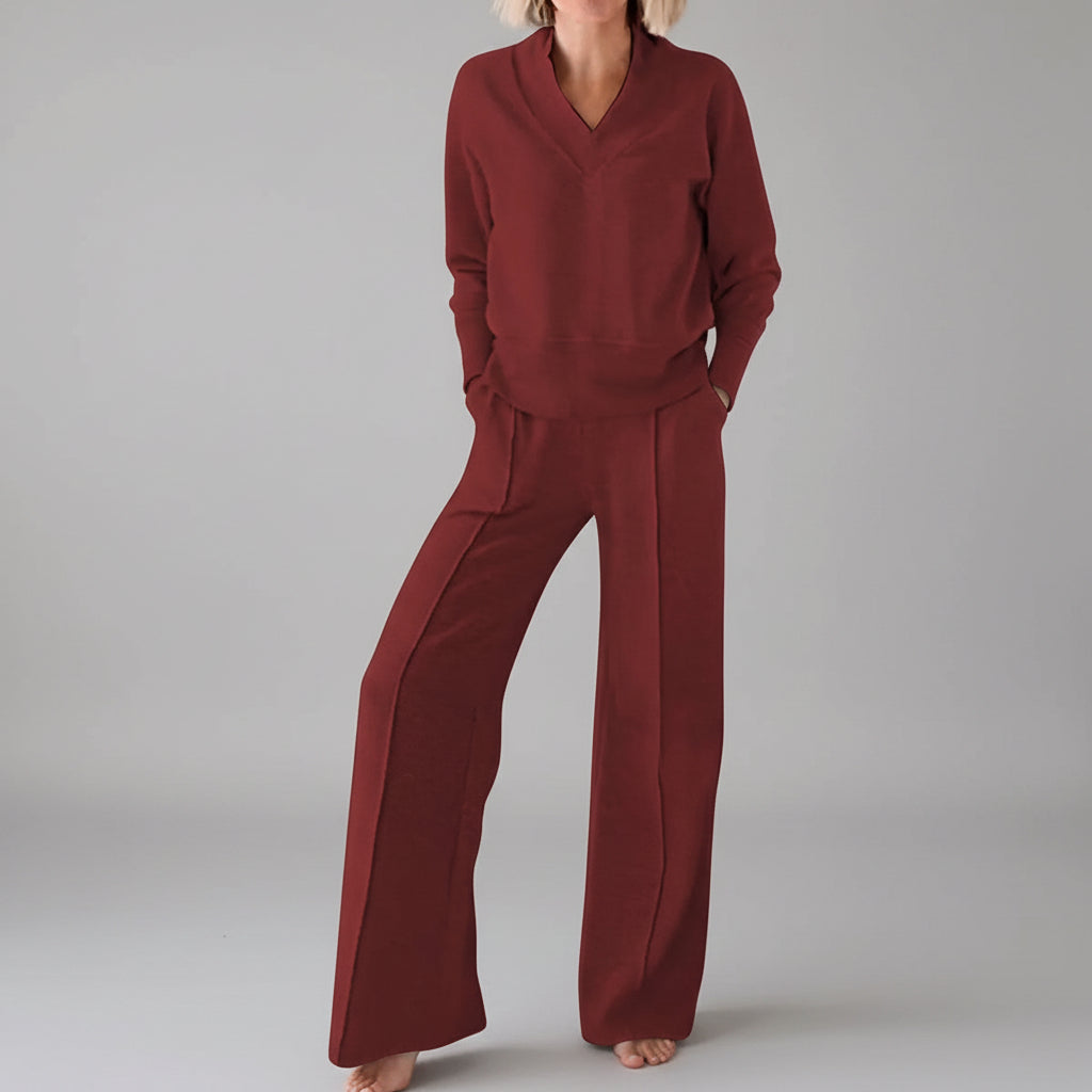 Person wearing a red outfit in a room with clothes in the background