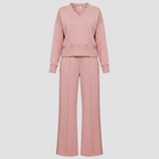 A two-piece women's loungewear set in a dusty rose pink color, featuring a long-sleeve cropped V-neck sweatshirt and matching wide-leg trousers, shown on a light gray background.