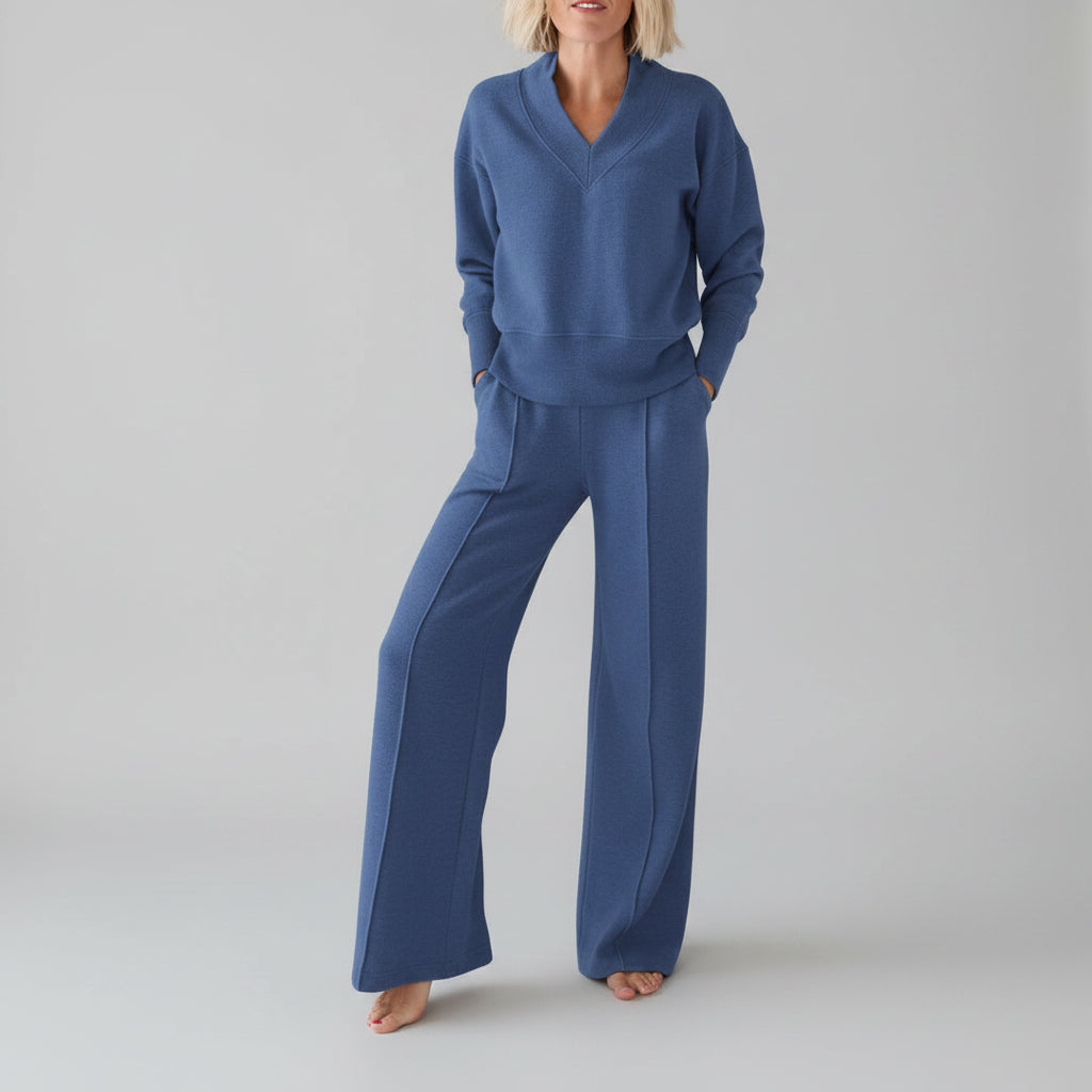 Person wearing a blue outfit in a room with clothes in the background