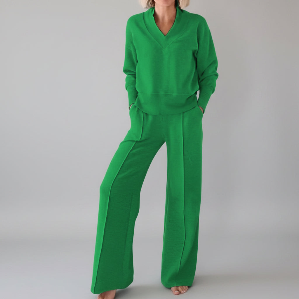 Person wearing a green outfit in a room with clothes in the background