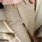Close-up of beige pants with a button on a neutral background