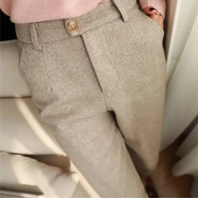 Close-up of beige pants with a button on a neutral background