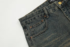 Close-up of blue jeans with a brand label on a light gray background