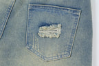 Close-up of a blue denim pocket with a decorative lace patch.