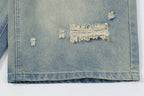 Close-up of a distressed denim jacket with frayed edges on a white background