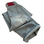 Folded pair of light blue jeans on a white background
