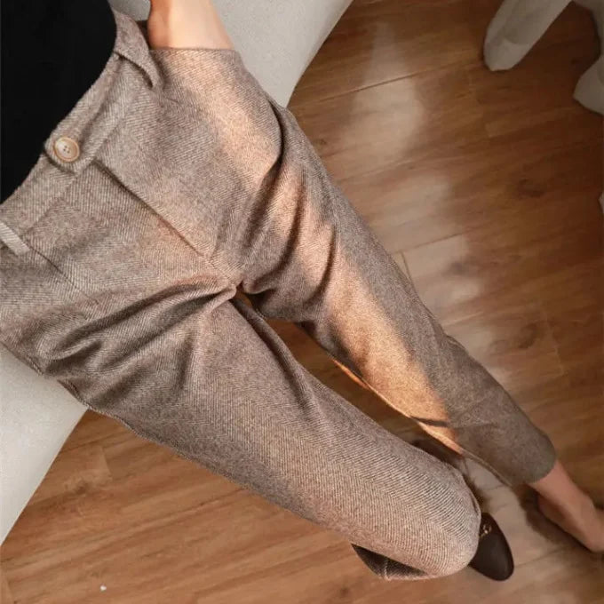 Brown textured pants worn by a person on a wooden floor