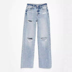 Light blue jeans with distressed details on a white background