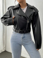 Person wearing a black leather jacket and light blue jeans against a white background