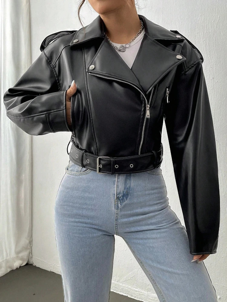 Person wearing a black leather jacket and light blue jeans against a white background