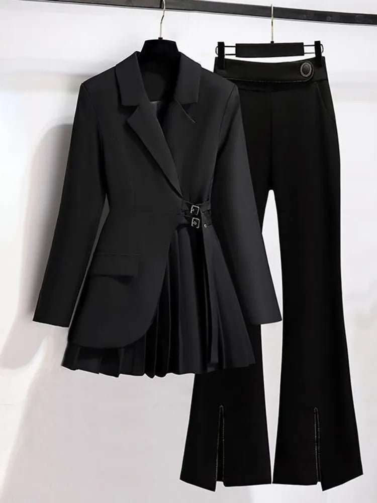 Black blazer and high-waisted pants on hangers against a white background
