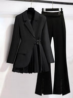 Black blazer and high-waisted pants on hangers against a white background
