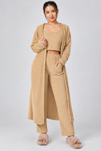 Woman wearing a beige outfit with a matching cardigan on a white background
