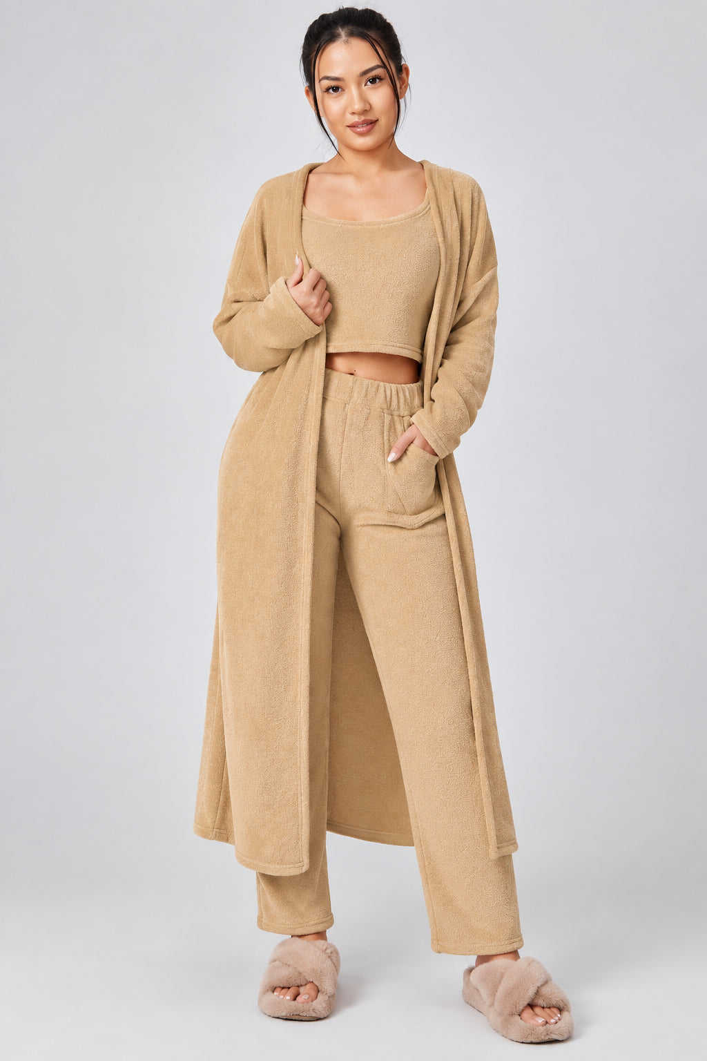 Woman wearing a beige outfit with a matching cardigan on a white background