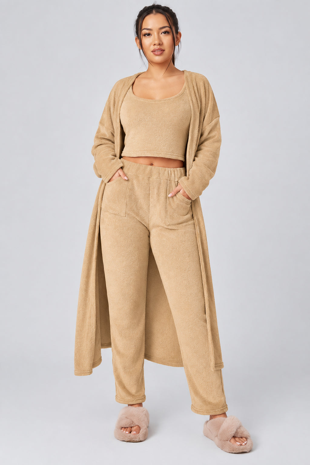 Woman wearing a beige outfit with a long cardigan on a white background