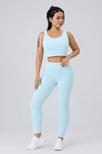Woman wearing a light blue athletic outfit on a white background