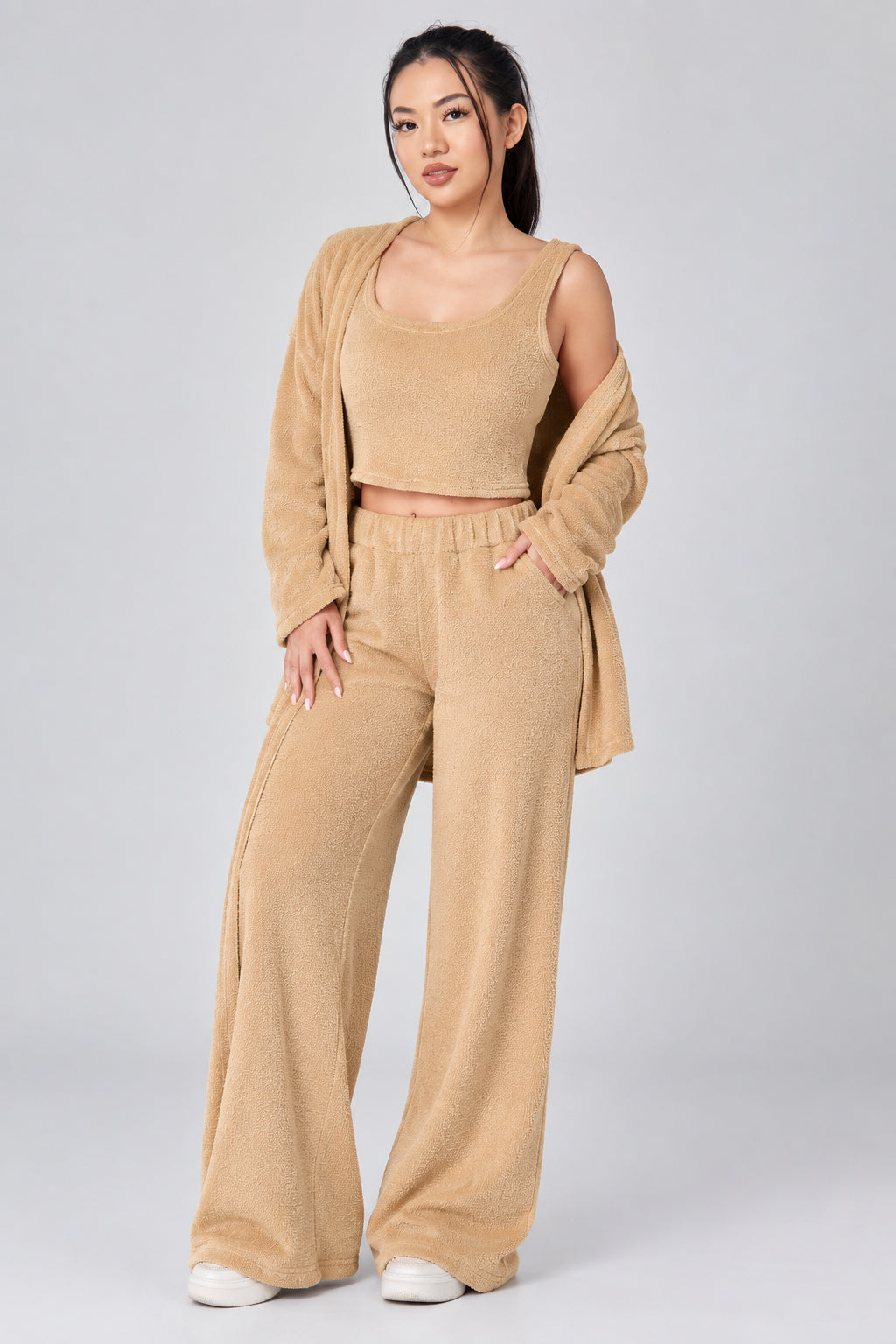 Woman wearing a beige outfit on a plain background