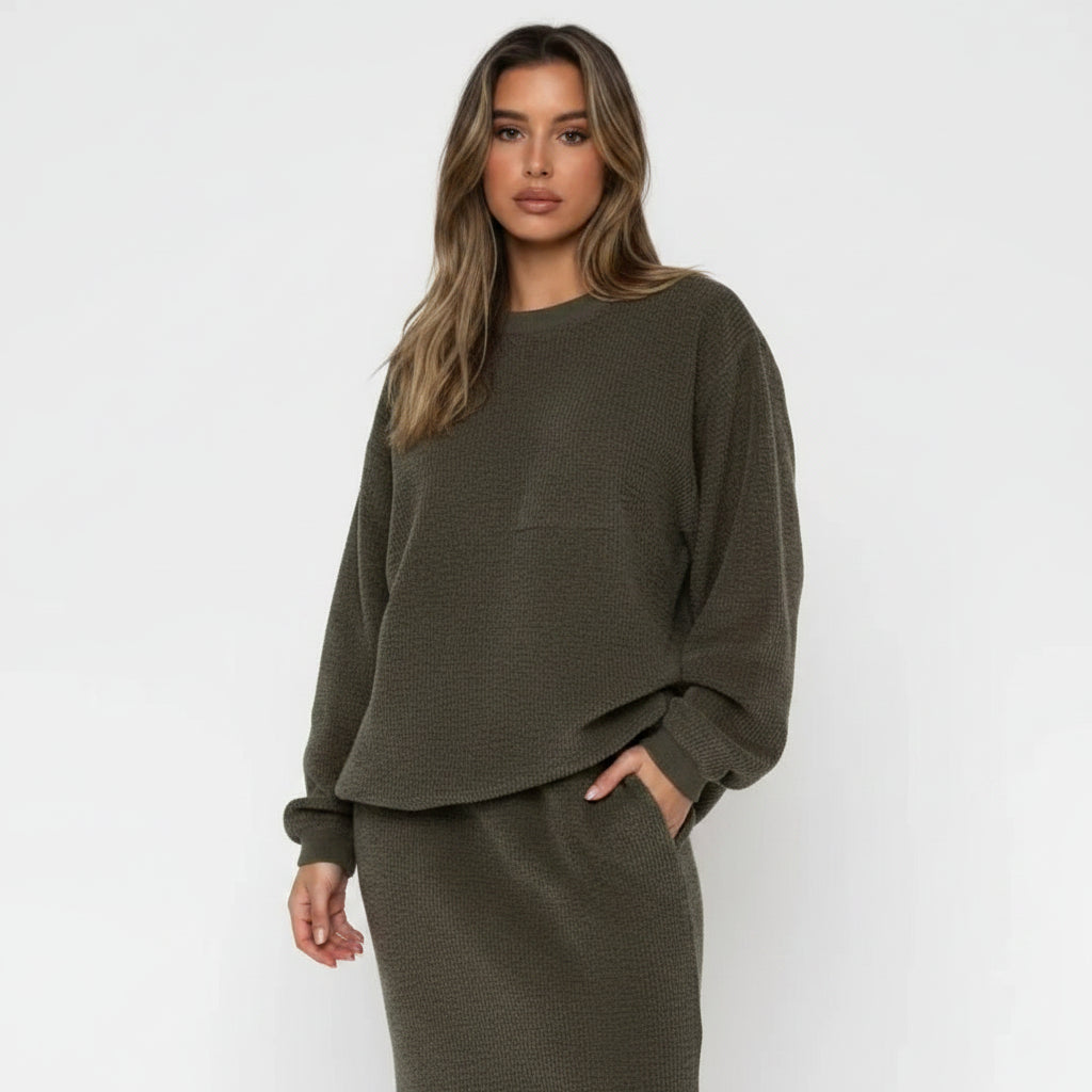 Woman wearing a green oversized sweater against a white background