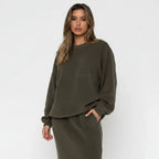 Woman wearing a green oversized sweater against a white background