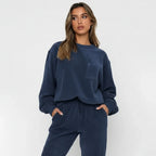 Woman wearing a navy blue lounge set against a white background