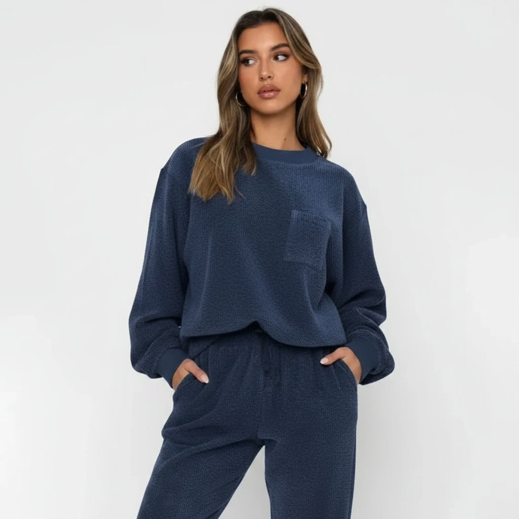 Woman wearing a navy blue lounge set against a white background