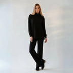 Woman wearing a black outfit against a plain background