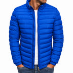 Blue puffer jacket worn by a person on a white background