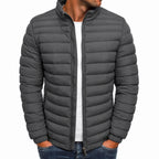 Gray puffer jacket worn by a person on a white background