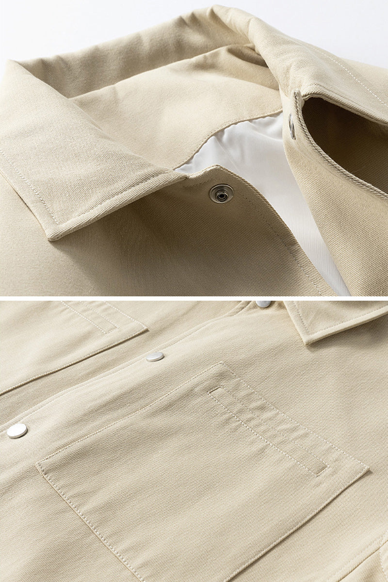 Close-up of a beige jacket with a button and collar detail on a white background