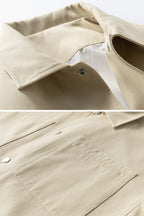 Close-up of a beige jacket with a button and collar detail on a white background