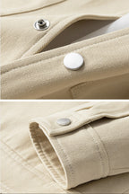 Close-up of beige fabric with buttons and stitching details