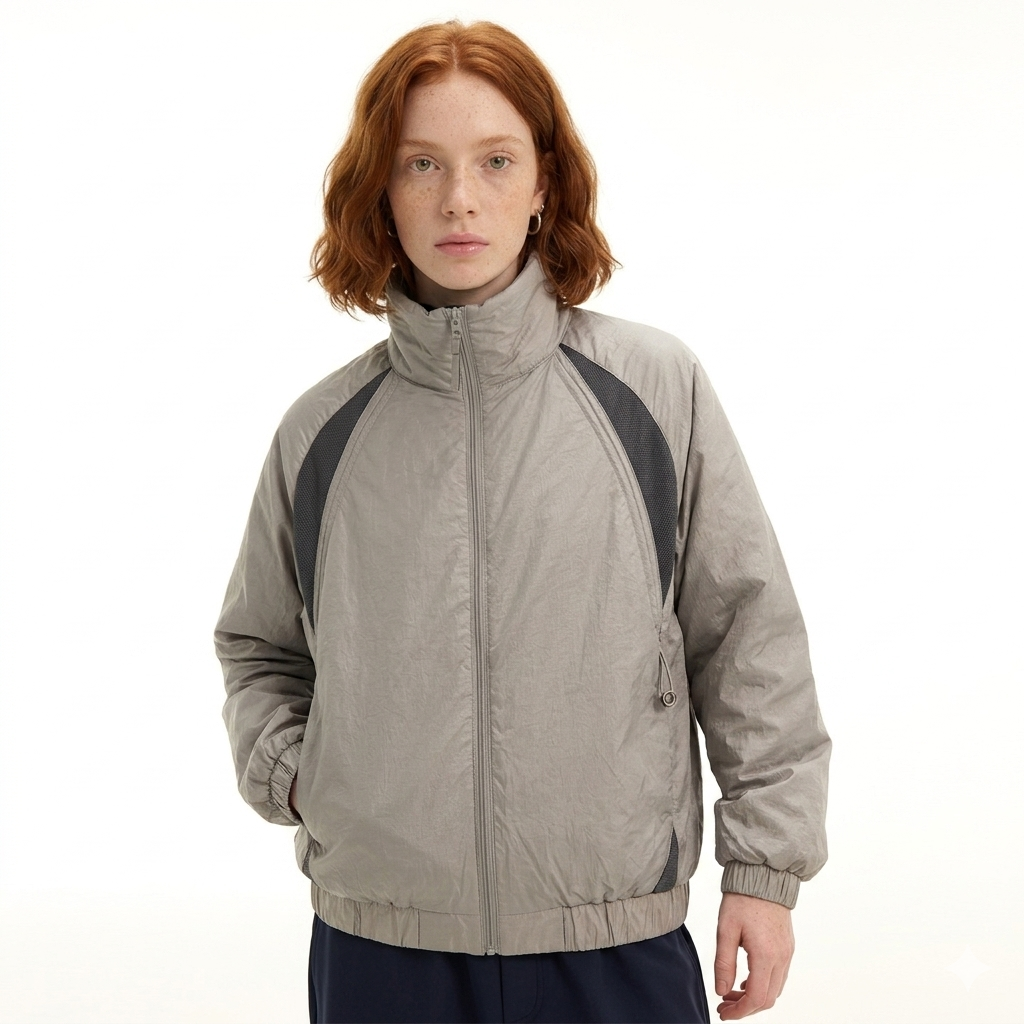 Person wearing a gray jacket with black accents on a white background