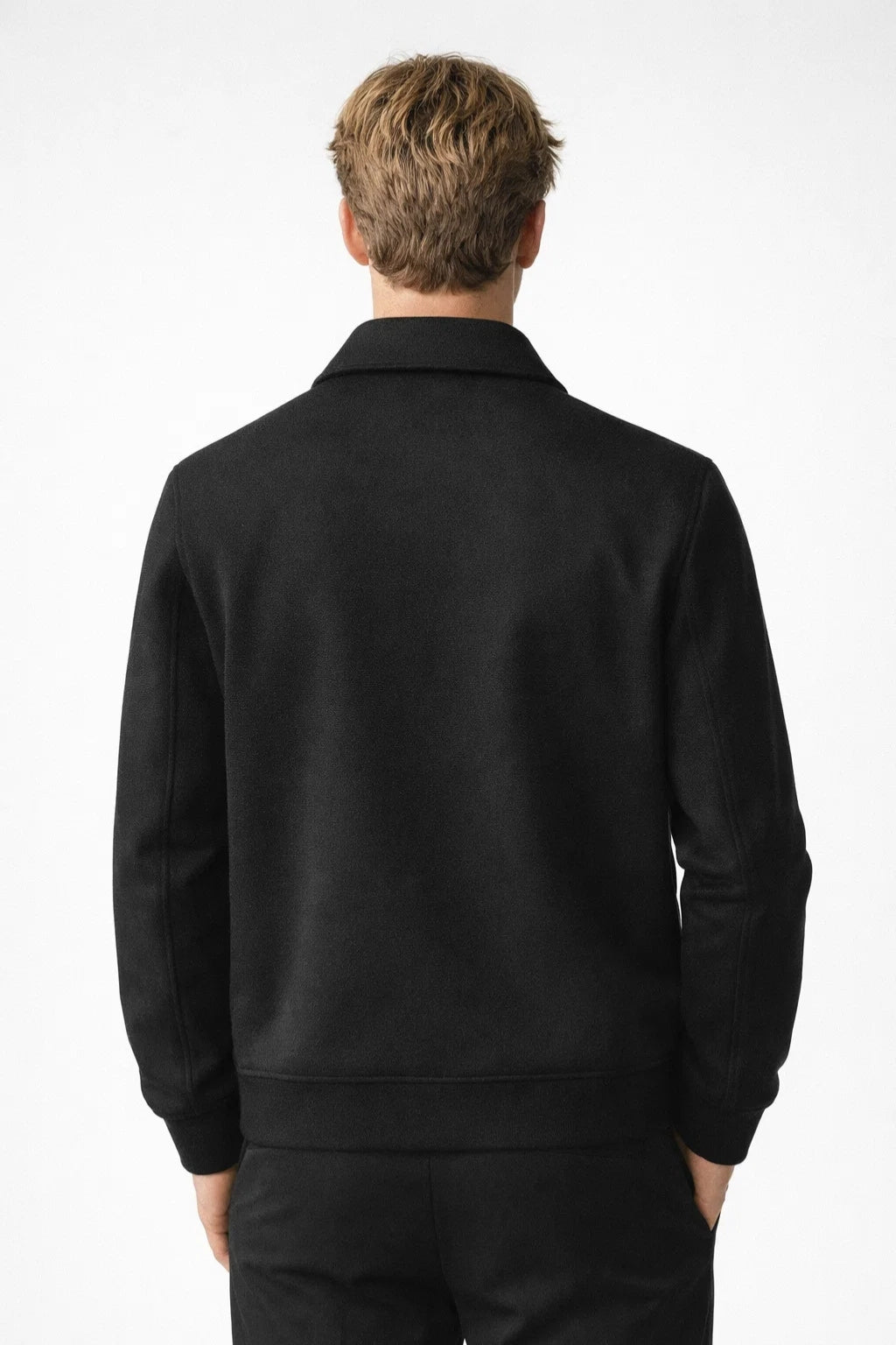 Person wearing a black jacket on a white background