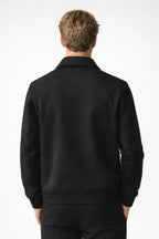 Person wearing a black jacket on a white background