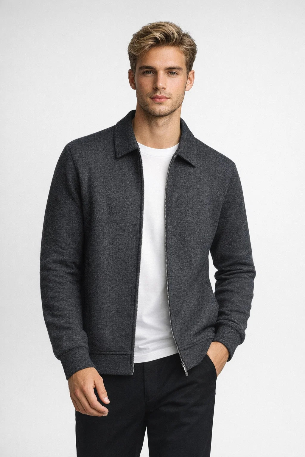 Man wearing a gray jacket over a white shirt on a light gray background