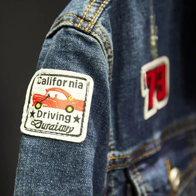 Denim jacket with patches on a dark background