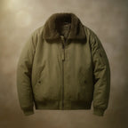 An olive green military-style bomber jacket with a brown faux-fur collar, shown against a warm, textured brown background.