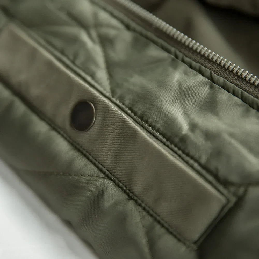 Close-up of a green jacket with a zipper and button detail
