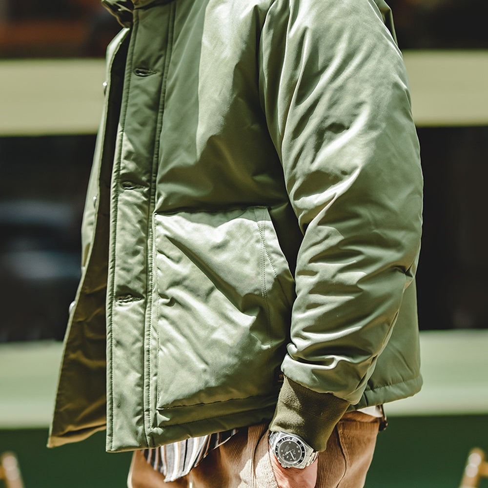 Person wearing a green jacket with a blurred background