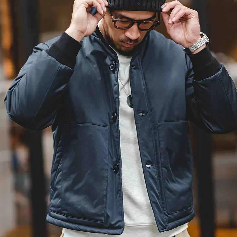 Man wearing a navy blue jacket with a blurred background