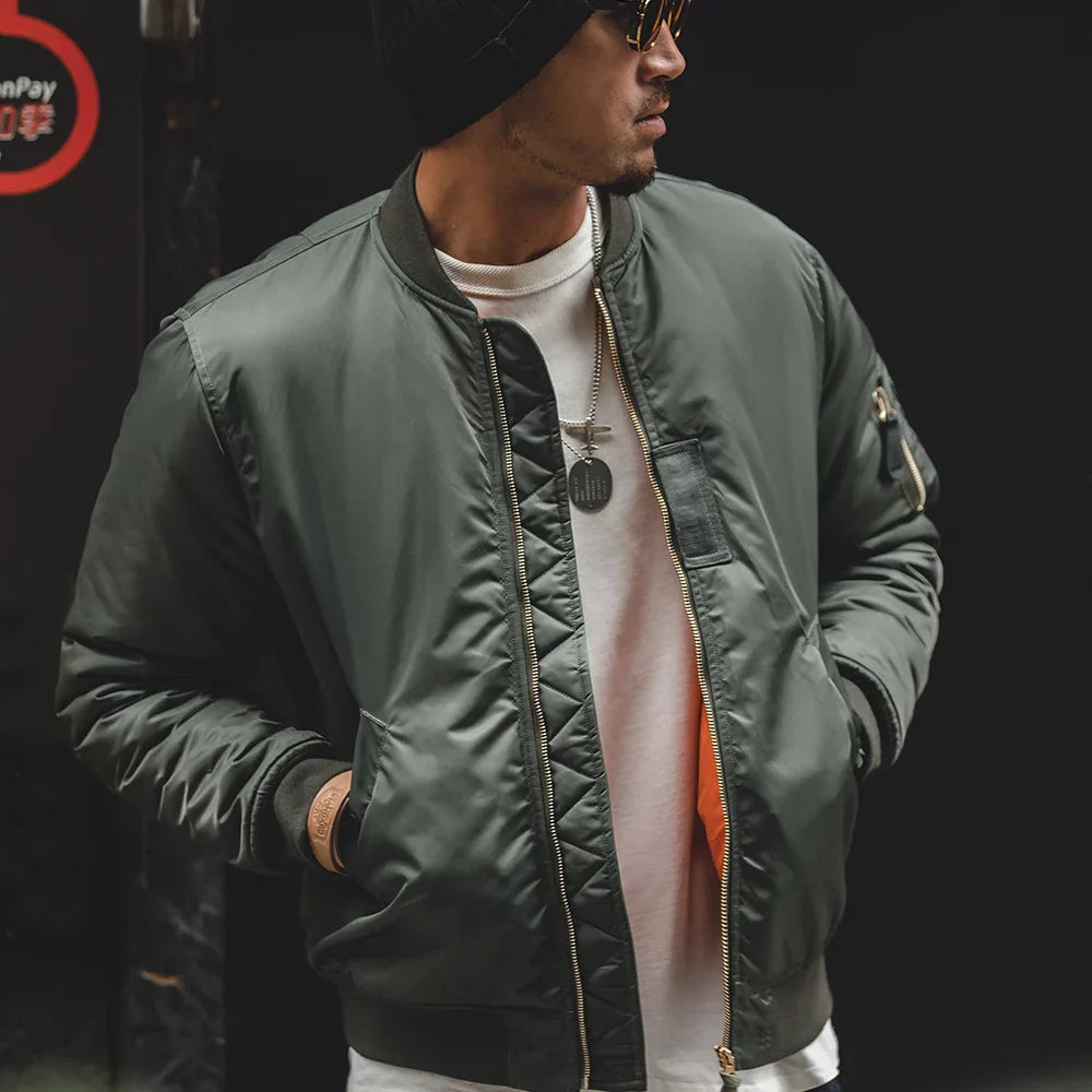 Man wearing a green bomber jacket with a dark background