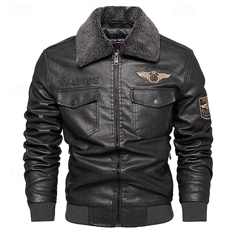 Black faux leather bomber jacket with a dark gray sherpa collar, zippered front, flap chest pockets, and embroidered patches on the chest and sleeve, shown on a plain white background.