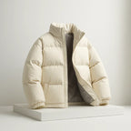 Beige puffer jacket on a white platform with a light gray background