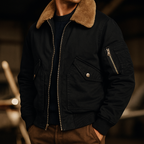 Black jacket with brown fur collar worn by a person, blurred background