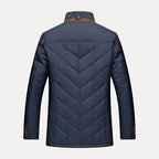 Navy blue quilted jacket on a light gray background