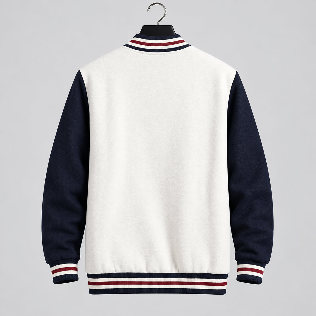 A varsity-style jacket with a light gray body and dark navy sleeves, hanging against a gray tiled wall. The collar, cuffs, and hem feature red and white stripes, and the word 'Supzoom' appears in the top left corner.