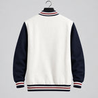 A varsity-style jacket with a light gray body and dark navy sleeves, hanging against a gray tiled wall. The collar, cuffs, and hem feature red and white stripes, and the word 'Supzoom' appears in the top left corner.