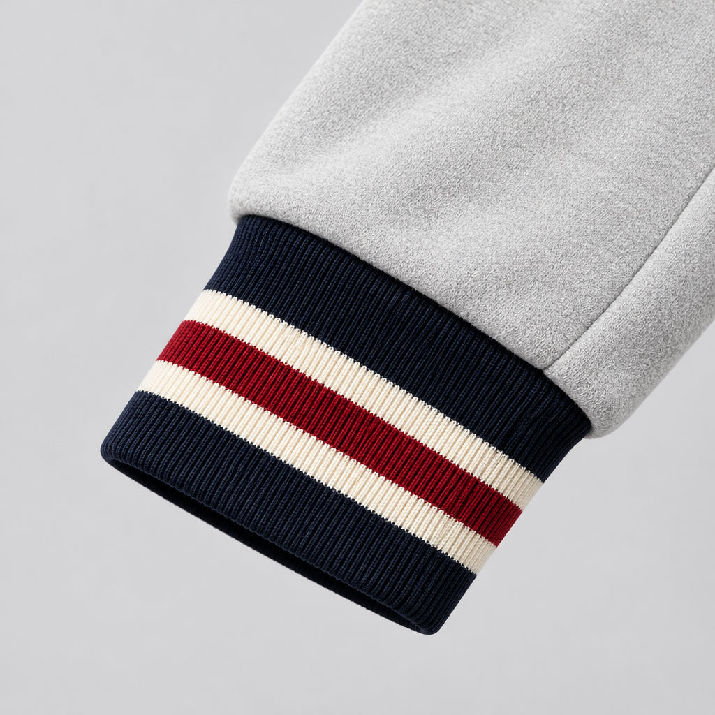 Close-up of a white jacket with black and red striped trim, featuring the brand 'Supzoom'.