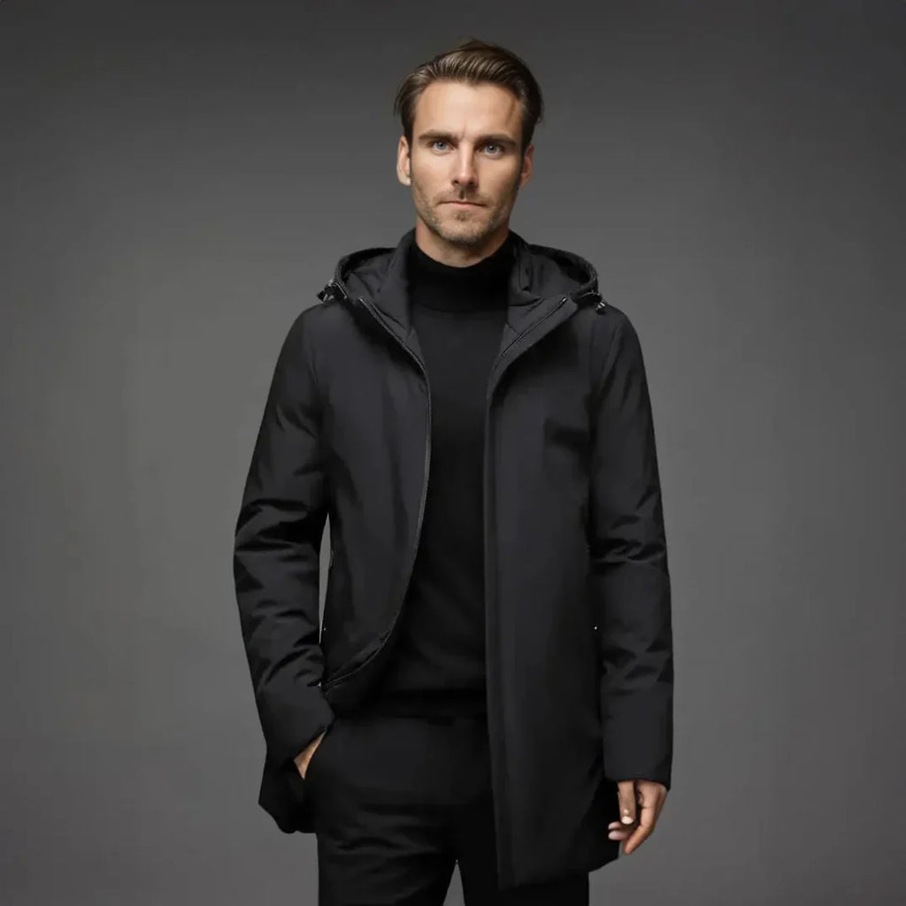 Man wearing a black coat against a gray background